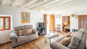 Un salon avec un canapé, une table basse et un téléviseur.