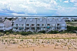 A beachfront hotel with multiple balconies, a sandy beach in front, and a view of the ocean. - Beach Front Villa with 4 Bedrooms & 4 Bathrooms near Fenwick Island! Fenwick Beach Front! (Fenwick Island)