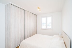 Une chambre à coucher avec un lit, une fenêtre et une armoire.