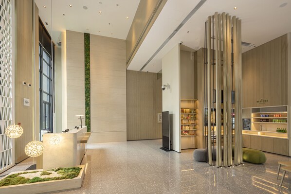 A modern lobby with a reception desk, seating area, and a section with bottled beverages. - Element Xiamen Tong'an (Xiamen)