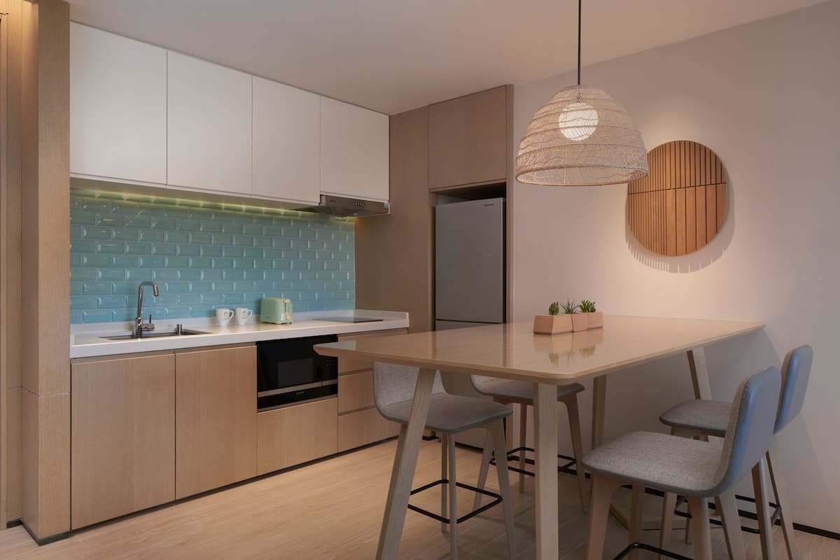 A modern kitchen with a wooden countertop, a built-in oven, and a hanging light fixture.