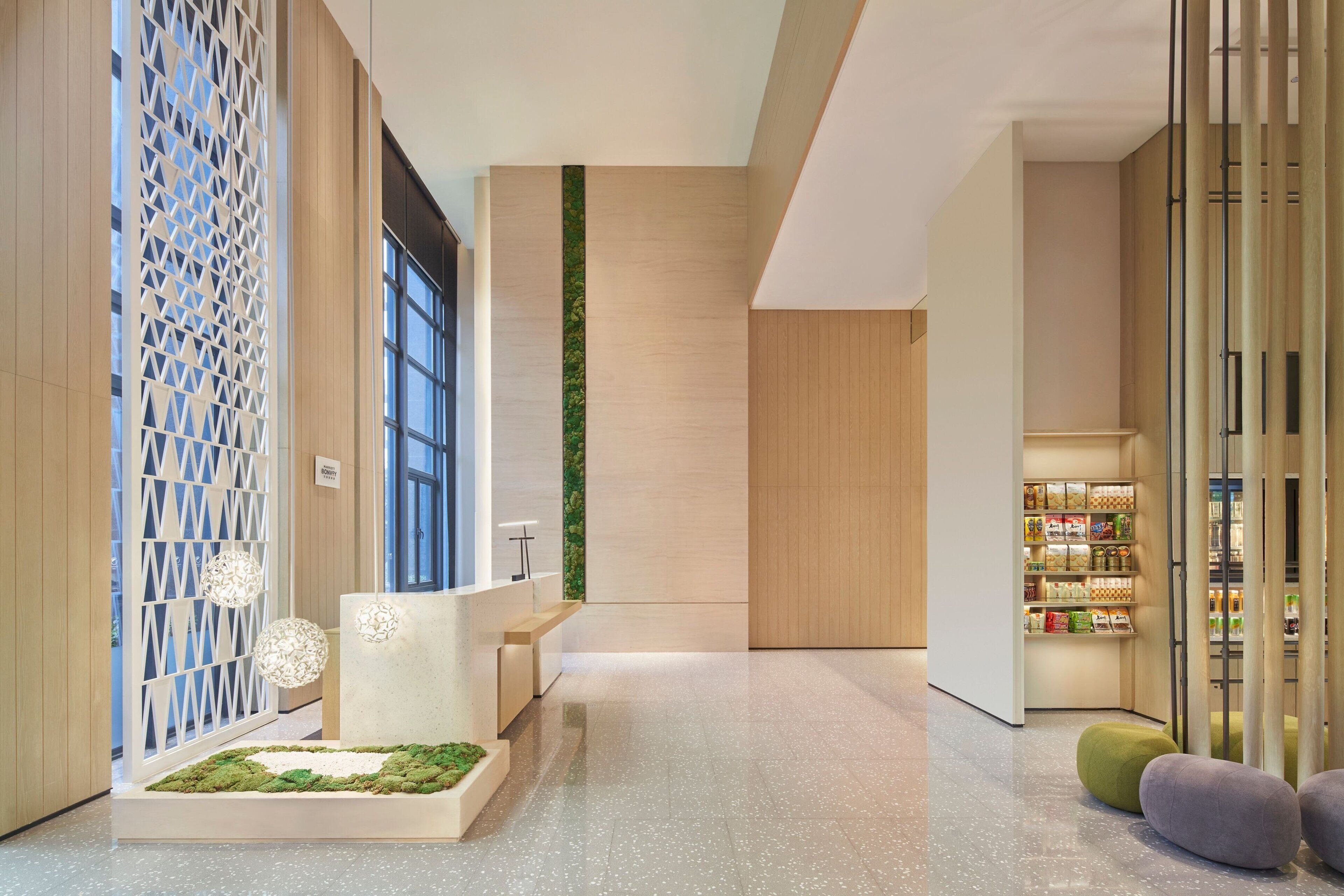 A modern reception area with a reception desk, seating, a plant display, and a section with products.