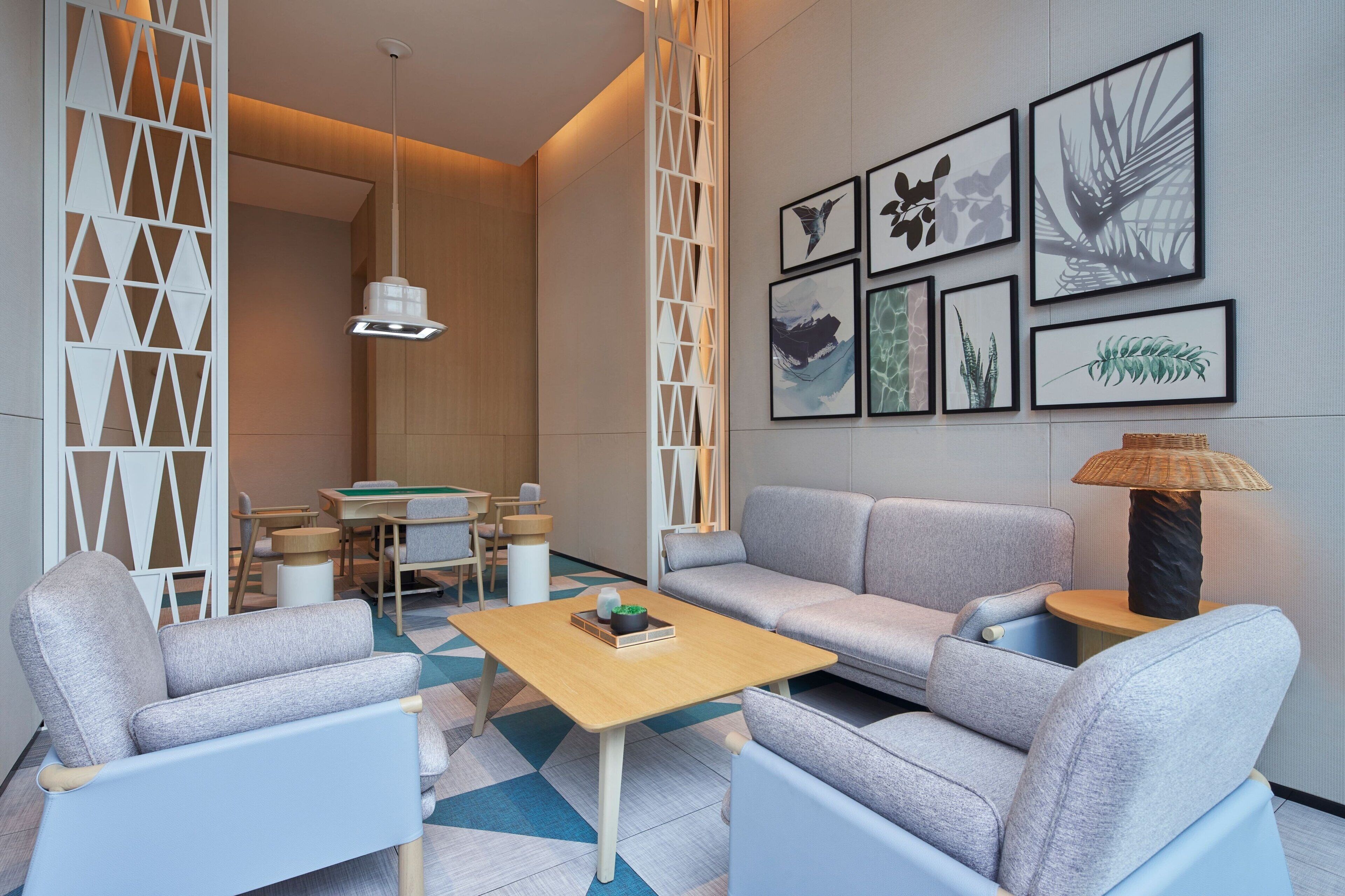 Una sala de estar moderna con un sofá, sillones, una mesa de centro y un comedor con sillas y una mesa.