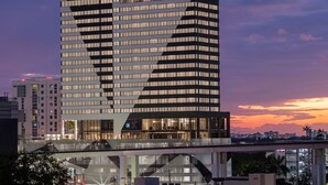 A modern high-rise building with multiple floors, large windows, and a rooftop terrace. -  AC Hotel by Marriott Miami Brickell (Miami)