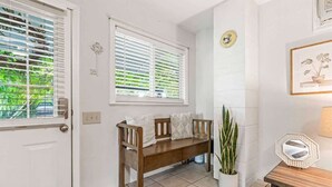 A clean, well-lit entryway with a wooden bench, a potted plant, and a framed picture on the wall. - Downtown Caldwell | Golf Course View | Near I-84 | Fast WiFi | Sleeps 5 (Caldwell)