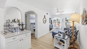 A spacious room with a kitchen, dining area, and a living space. There is a ceiling fan, a lamp, and nautical-themed decor. - Waterfront 1/1, sleeps 6, walk to beach! #B111 (Indian Shores)