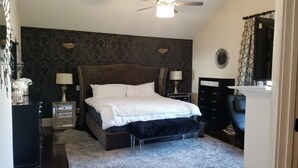 A bedroom with a large bed, two bedside tables, a dresser, a ceiling fan, and a window with curtains. - Beautiful Luxury Home near Smyrna Village & Braves Stadium (Smyrna)