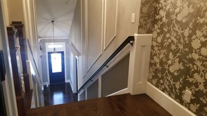 A staircase with a wooden handrail and a wall with floral wallpaper. - Beautiful Luxury Home near Smyrna Village & Braves Stadium (Smyrna)