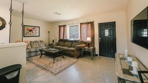 A living room with a sofa, coffee table, and a small side table with a lamp.
