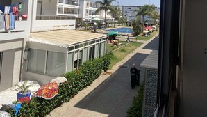 A hotel corridor with balconies, a pool area, and a clear sky. - Apartment Marbella beach 24/24 security (El Mansouria)