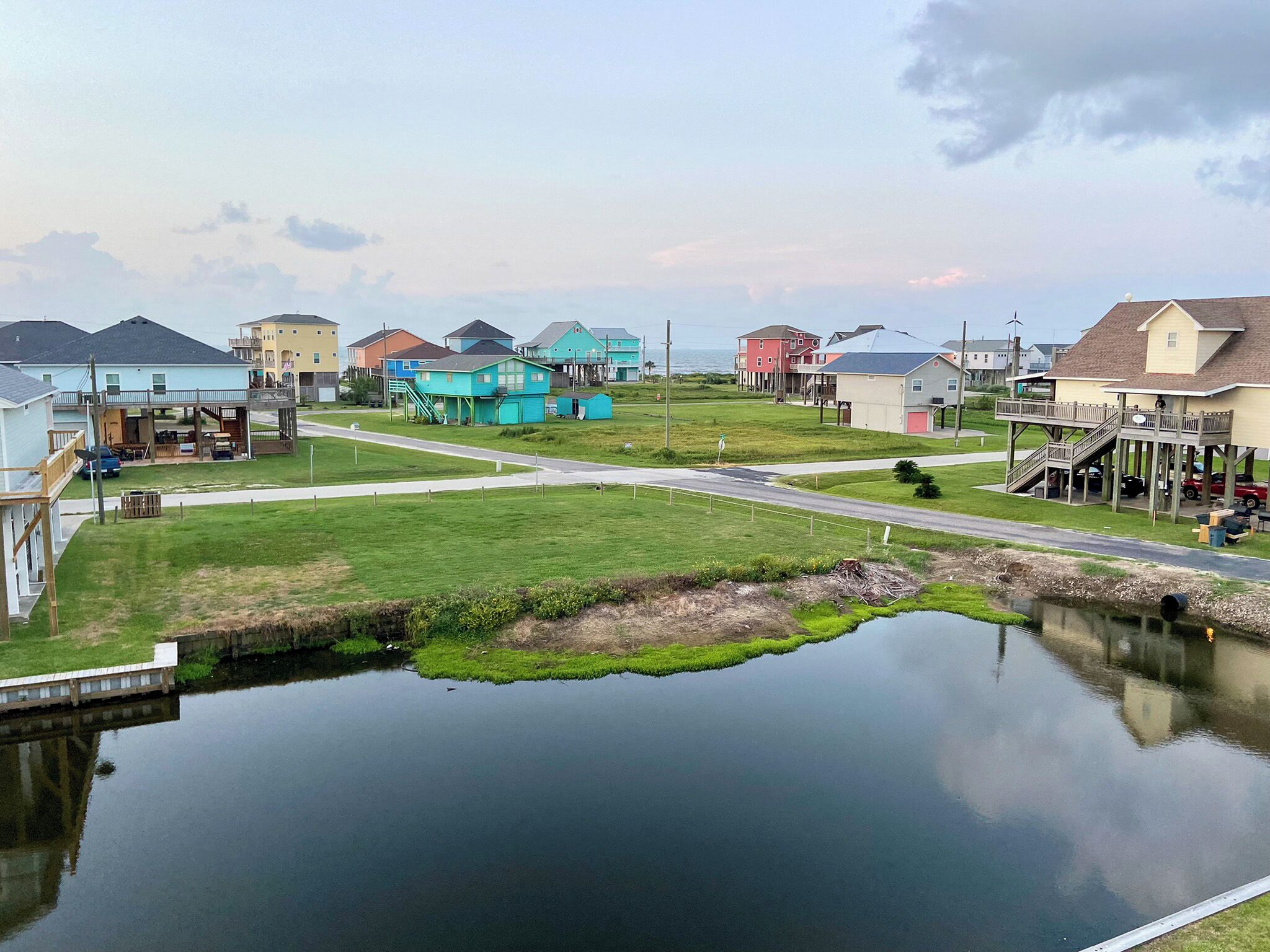 Un quartier résidentiel avec des maisons, un petit plan d’eau et une route.