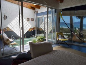 Enjoy ocean views from the comfort of your room, which features a bed, a table, and a chair, with access to an outdoor area.