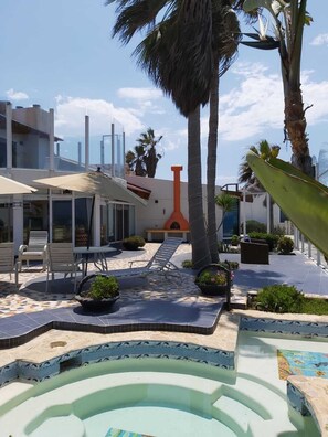 Relax by the clear blue pool surrounded by a tiled deck and lounge chairs.