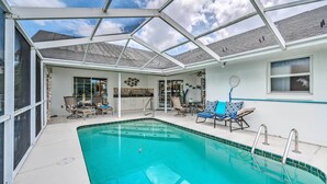 Una piscina coperta con lettini e un angolo cottura.