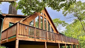 A wooden cabin with a balcony, large windows, and a chimney. - Spacious Cabin Right Next to Cacapon State Park (Berkeley Springs)