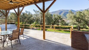An outdoor patio with a table and chairs, a pool, and a view of mountains.