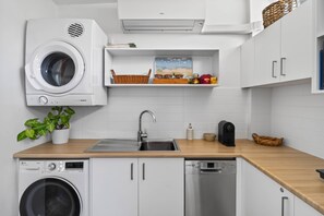 A kitchen with a washing machine, a sink, a microwave, and a dishwasher. - Stylish Studio in Heart of Annandale Village (Annandale)