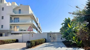 A modern multi-story residential building with balconies, a pedestrian crossing sign, and a gated entrance. - Panorama Beach - Brisa del Mar Apartment (Torrox-Costa)