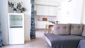 A compact living space with a kitchenette, a dining area, and a sofa. - Panorama Beach - Brisa del Mar Apartment (Torrox-Costa)