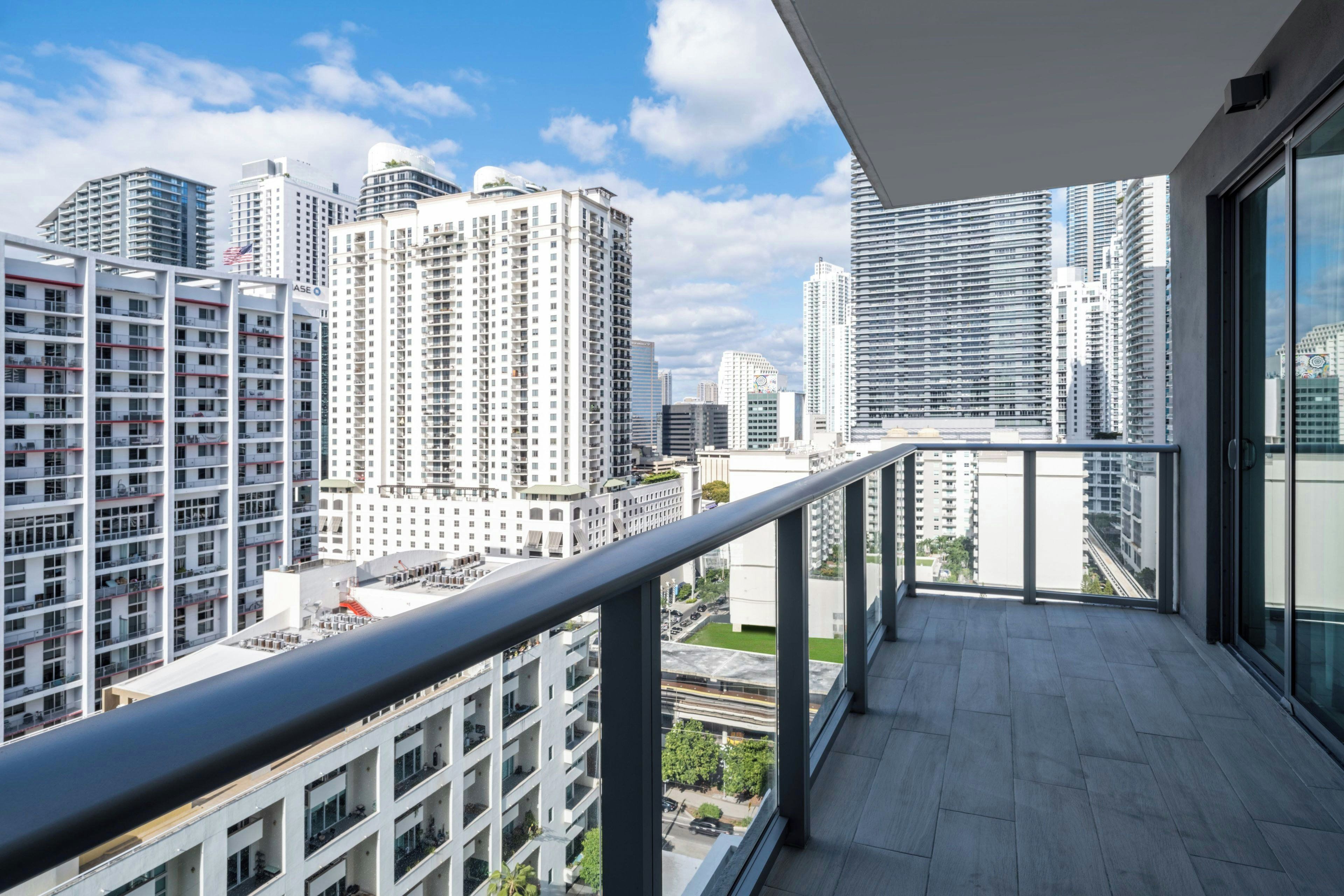A balcony with a city view overlooking high-rise buildings.