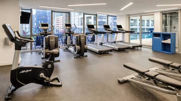 Un centre de remise en forme équipé de machines de cardio, de machines de musculation et d’une zone dédiée aux exercices de développé couché.