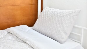 A neatly made bed with white bedding and a patterned blanket. - espectacular apartamento (Playa Juan Dolio)
