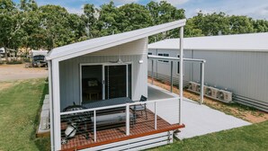 A modern RV with a covered porch and a sliding door leading to a living area. - Ingenia Holidays Townsville (Deeragun)