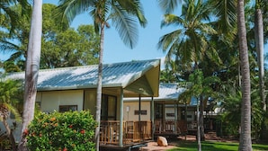 A bungalow-style hotel with a covered porch and a small garden area. - Ingenia Holidays Townsville (Deeragun)