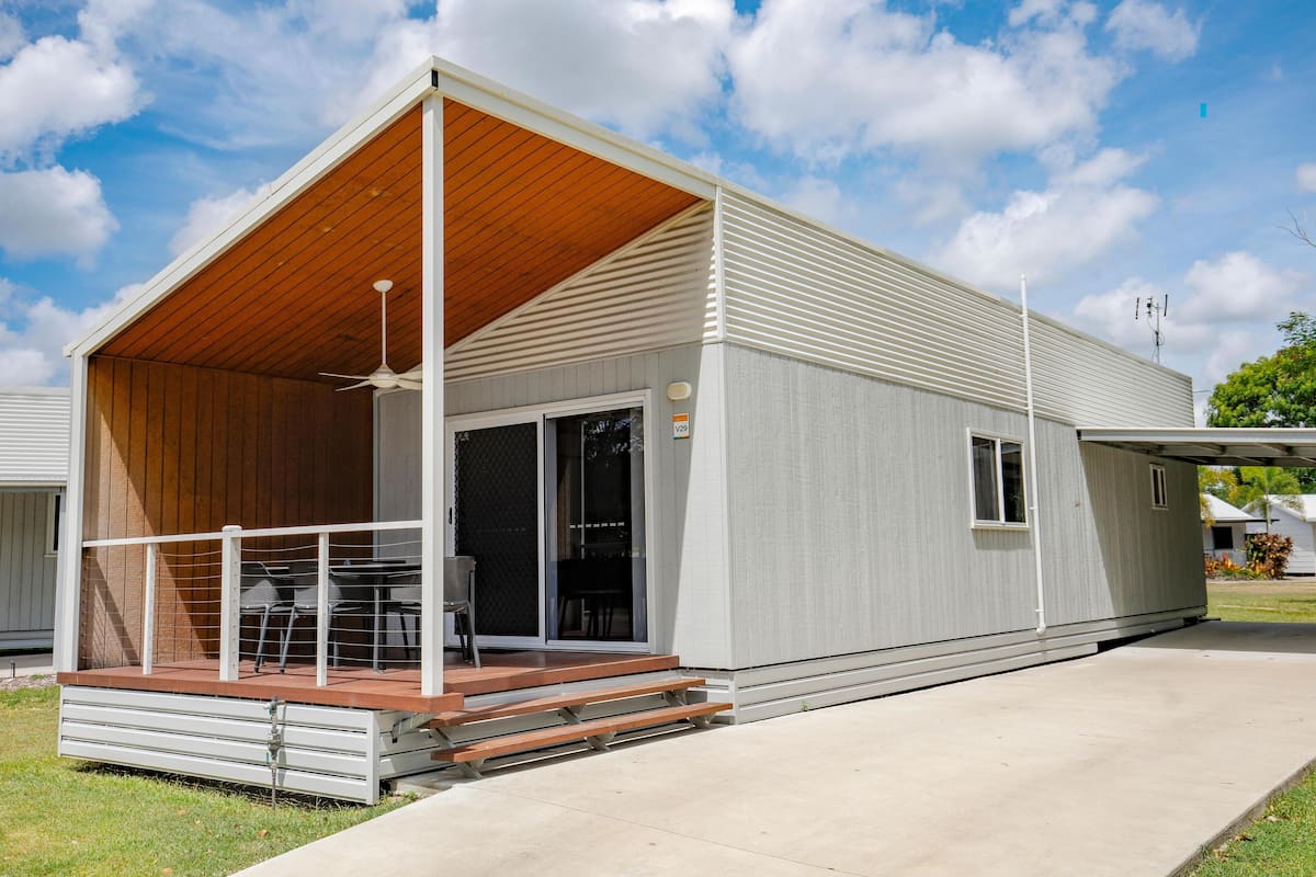 A modern single-story house with a covered patio, sliding glass doors, and a small deck.