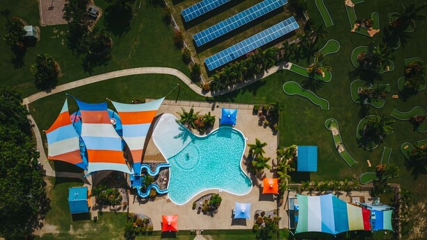 An aerial view of a resort with a swimming pool, water slides, and solar panels. - Ingenia Holidays Townsville (Deeragun)