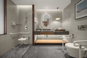 A modern bathroom with a shower, toilet, and sink.