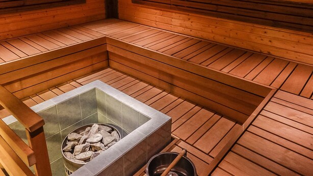 A sauna with wooden benches and a stone basin. - Porukka 2 by Interhome (Kittilä)