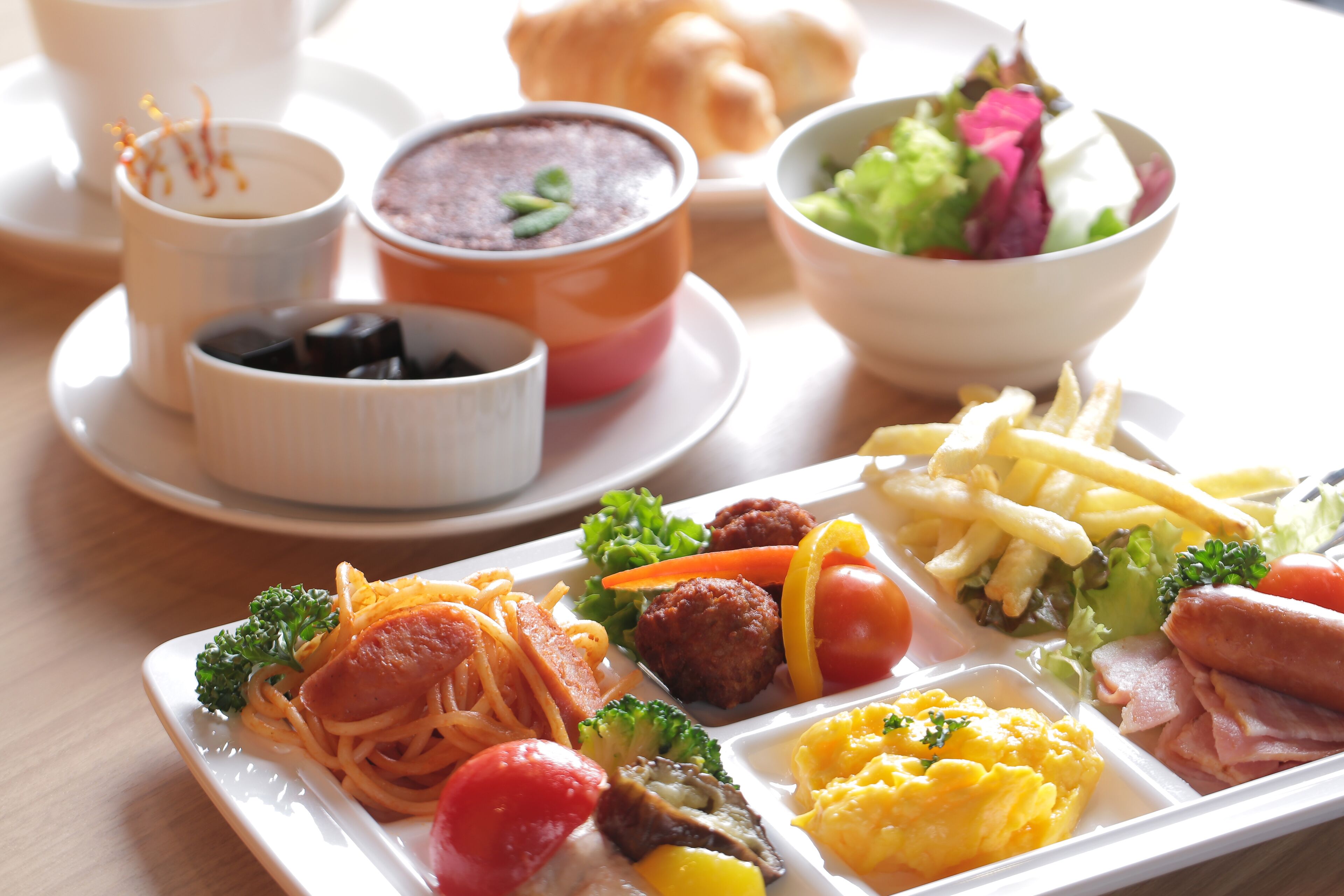 A variety of dishes including pasta, meatballs, and vegetables on a tray.