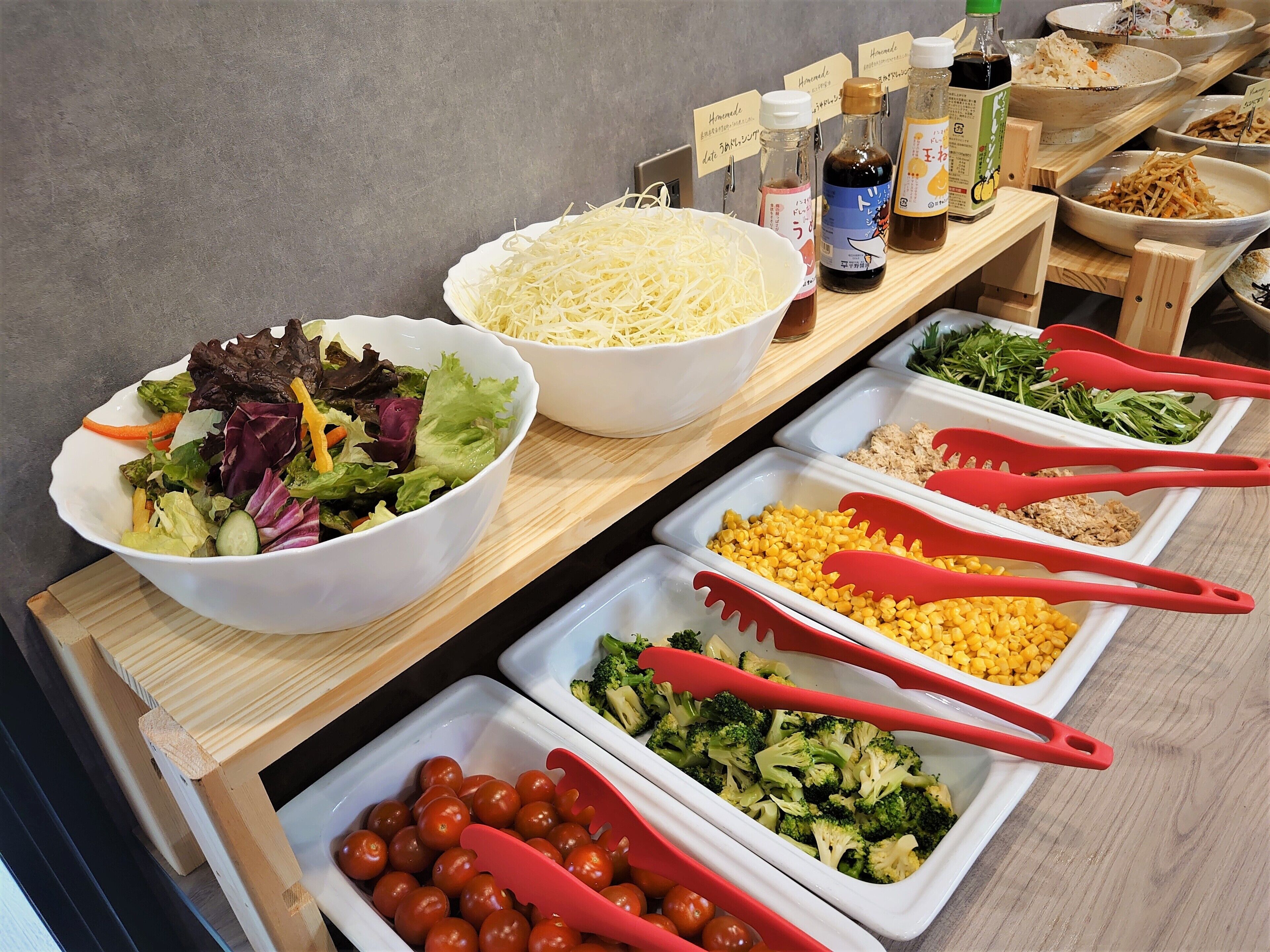 A buffet table with various food items and condiments.