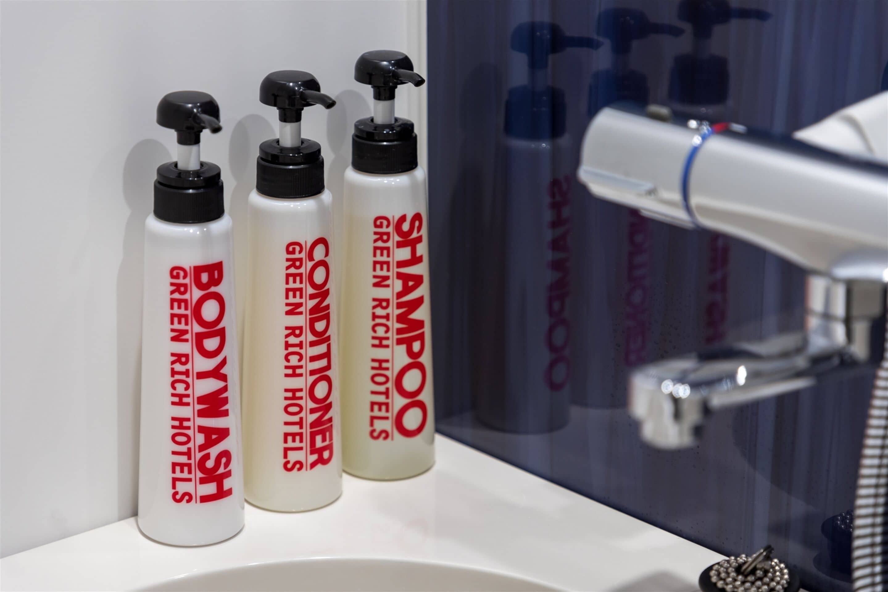 Three bottles of shampoo and conditioner on a bathroom counter.