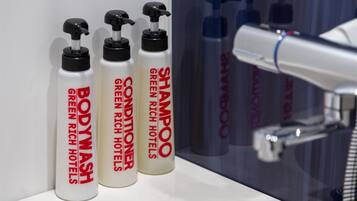 Three bottles of shampoo and conditioner on a bathroom counter.