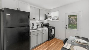 A compact kitchen with a refrigerator, stove, microwave, and sink. - * Beautiful Oasis w/ No Detail Spared * (Lutherville-Timonium)