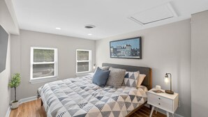 A bedroom with a bed, nightstands, a lamp, a picture on the wall, and windows with blinds. - * Beautiful Oasis w/ No Detail Spared * (Lutherville-Timonium)