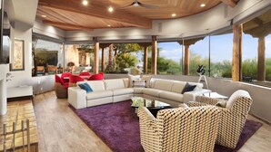 Una sala de estar moderna con un sofá modular grande, una mesa de centro y vistas al exterior.