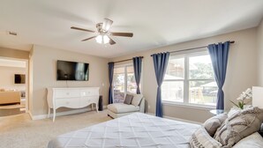 A bedroom with a bed, a ceiling fan, a TV, a dresser, and a window with curtains. - Private Dock & Slip: Cedar Creek Reservoir Home (Mabank)
