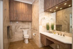 Een bad/douchecombinatie, een haardroger, handdoeken
