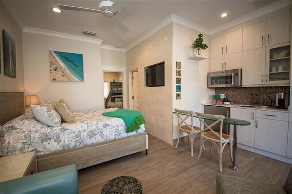 Un dormitorio con cama, escritorio y kitchenette.
