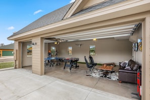 A garage with a table, chairs, and a sofa.