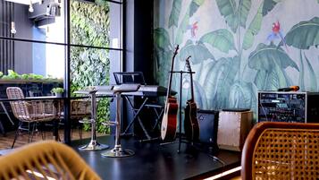 A modern interior with a stage, musical instruments, and a mural of tropical birds.