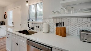 A modern kitchen with a white countertop, stainless steel appliances, and a hexagonal tile backsplash. - Camelback Casa | Old Town Scottsdale | New Remodel (Scottsdale)