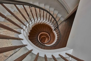 Un escalier en colimaçon avec des balustrades en bois et des marches blanches.