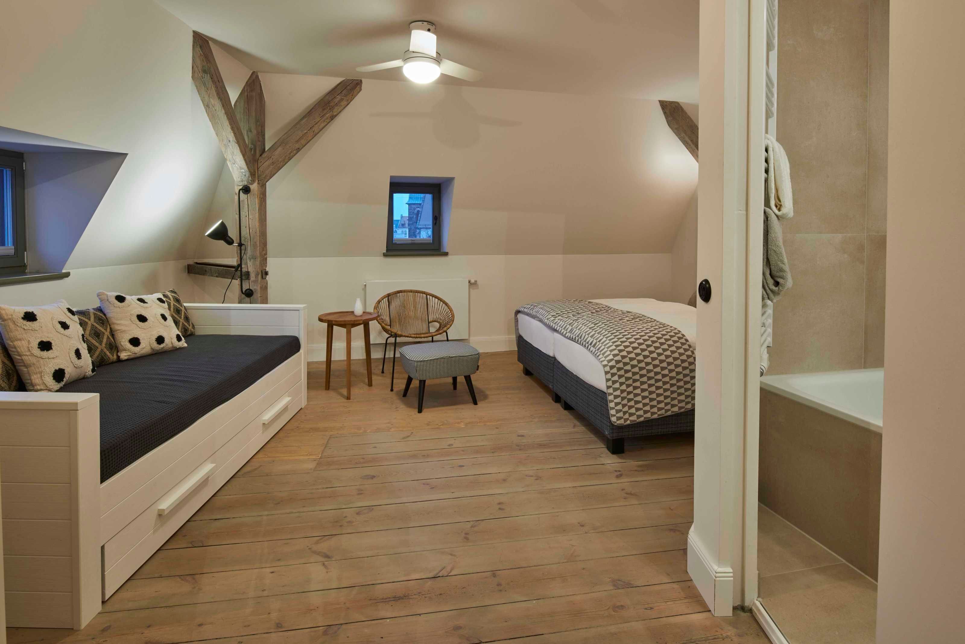 Une chambre avec un lit en mezzanine, une petite table, une chaise et une fenêtre.