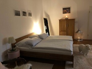 A bedroom with a bed, bedside lamp, wooden wardrobe, and a small rug. - Schlafkoje Kleine Wolke - Schäfchenwolke Apartment auf dem Bauernhof (Worpswede)