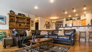 A cozy living room with a leather sofa, wooden coffee table, and a patterned rug. - ❄Ski in/out❄- Best Group Rental on Schweitzer-  Book now for holidays! (Sandpoint)