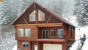 A two-story wooden house with a garage, large windows, and a balcony. - ❄Ski in/out❄- Best Group Rental on Schweitzer-  Book now for holidays! (Sandpoint)
